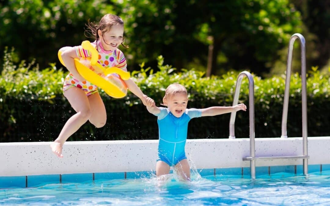 Two children jumping into a swimming pool, highlighting the importance of stringent pool fence regulations for safety in Australian swimming pools.