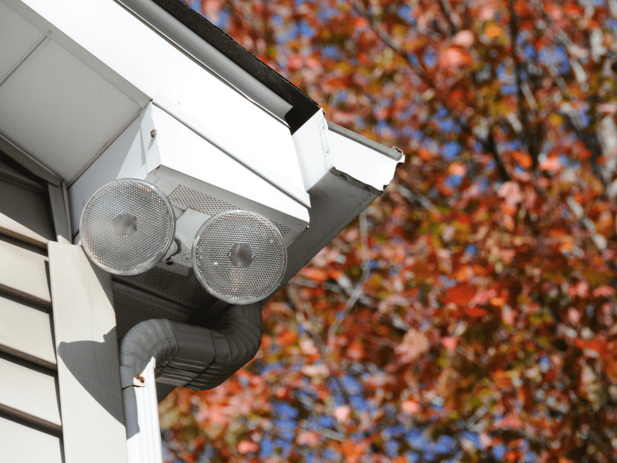 Sensor security lights attached to the corner of the outside of a house.