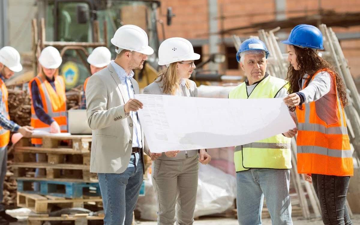 Construction workers wearing hard hats whilst having a team meeting.