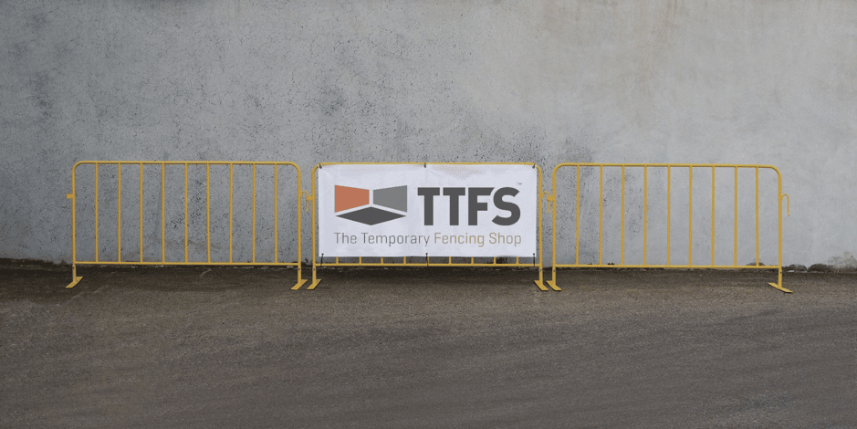 Yellow crowd control barrier with a custom printed TTFS banner..