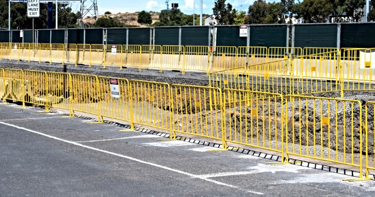 Rows of yellow pedestrian barriers on a road contruction site.
