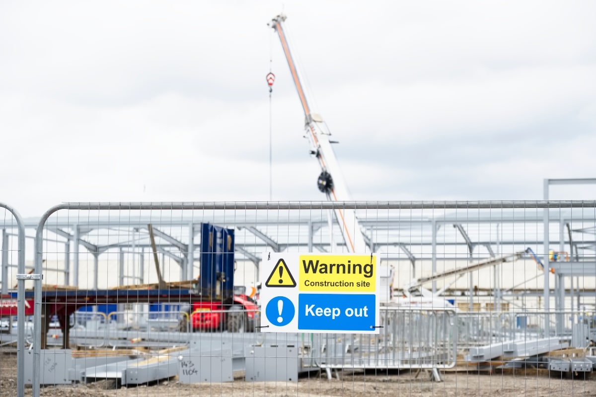 Construction site temporary fencing with signs to alert the public.