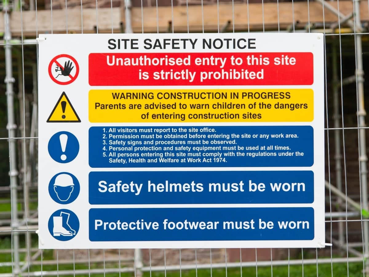 Site safety notice printed on corflute, attached to a fence.