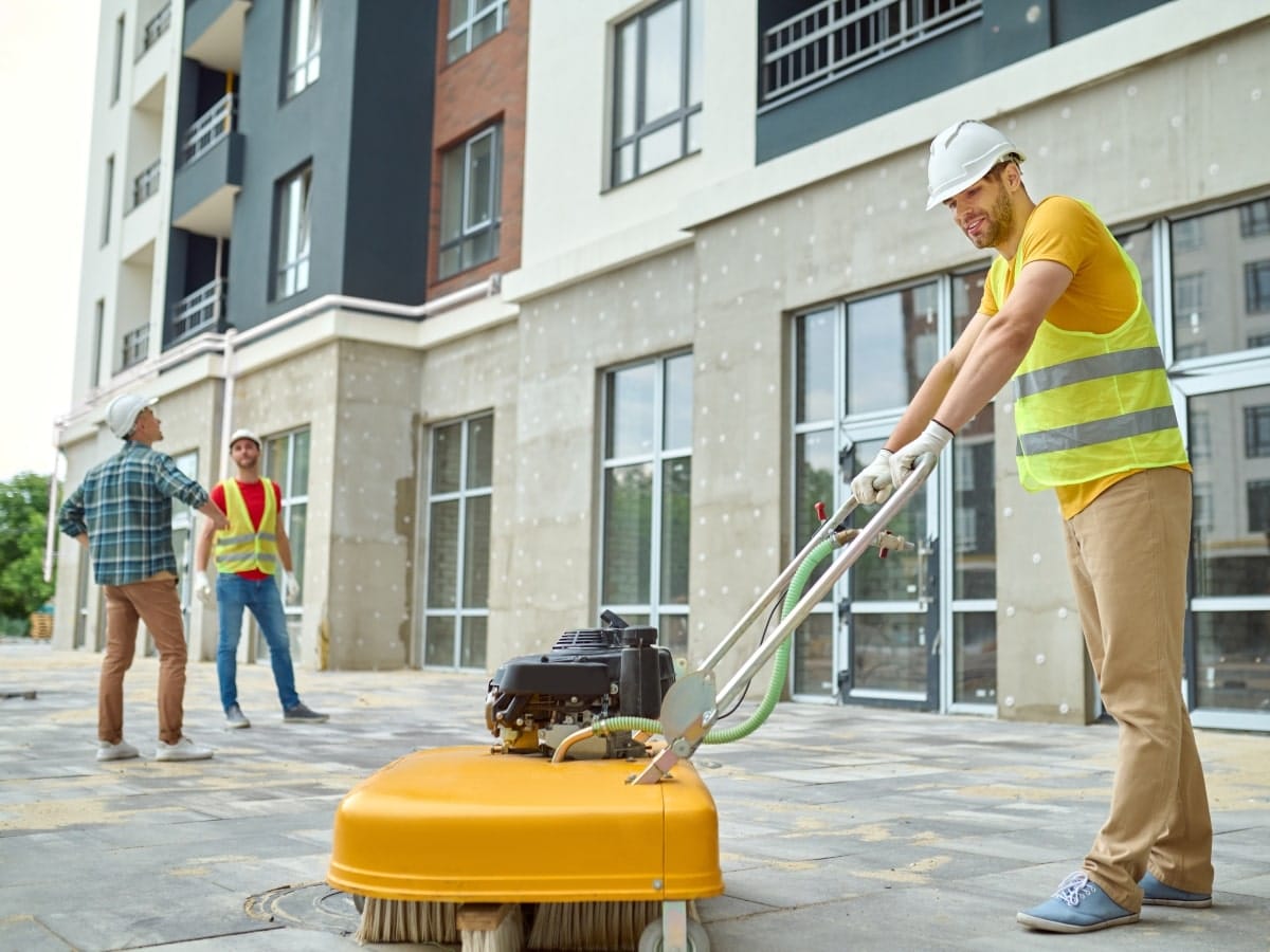 A worker using industrial  machine to clean the site after the project is completed.