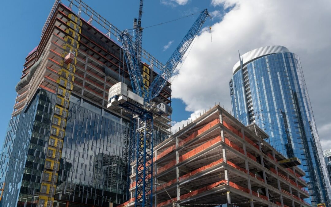 A view of a tall skyscraper under construction, showcasing various construction site hazards.