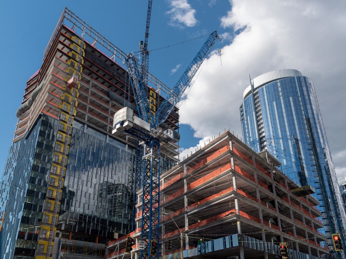 A view of a tall skyscraper under construction, showcasing various construction site hazards.