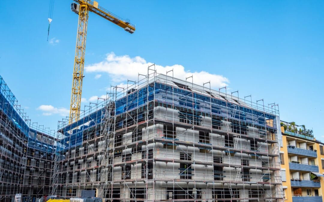 An image depicting the essential safety measures of edge protection on a multi-storey building under construction, with a towering crane in the backdrop.