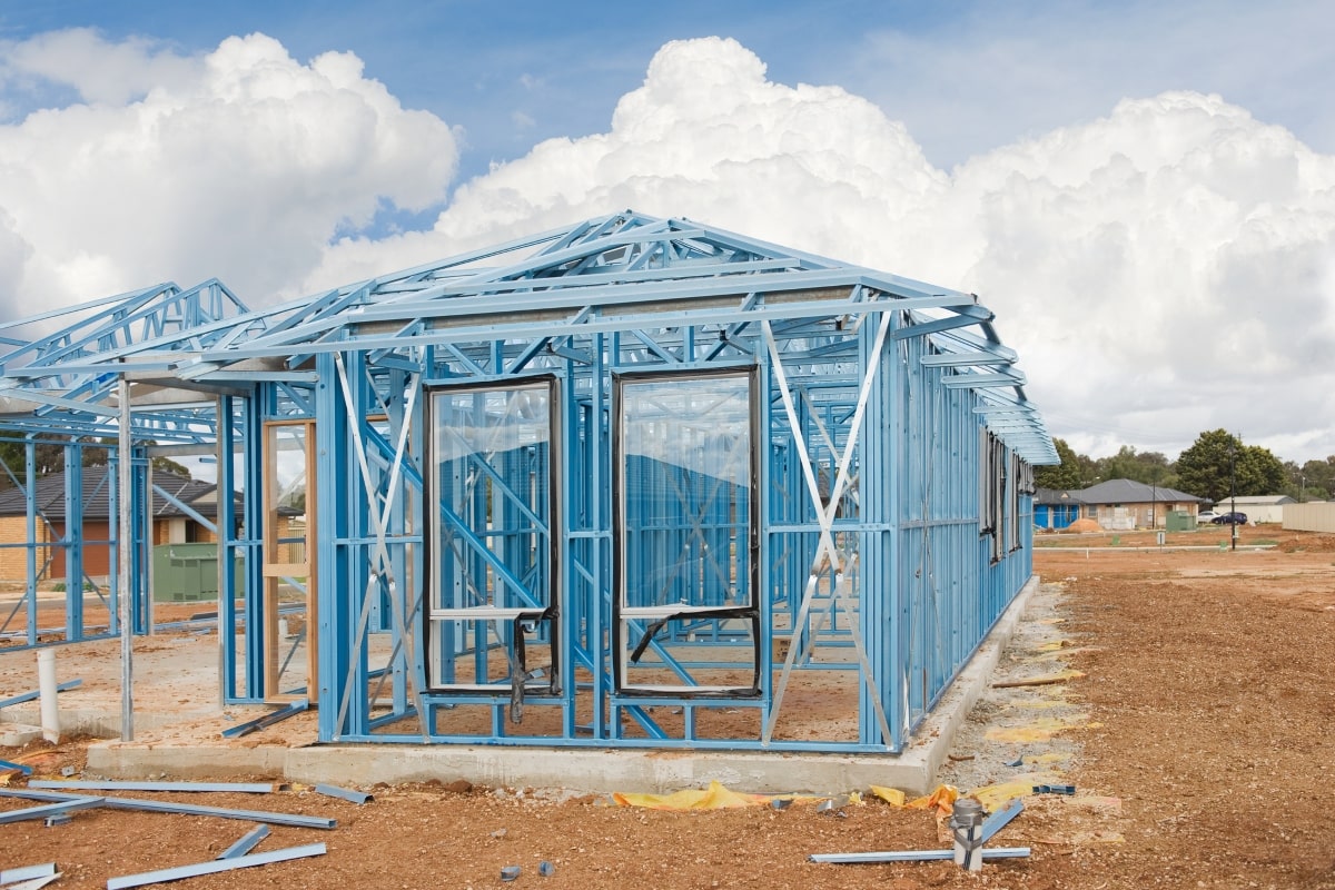 A new home at the framing stage with the structure's metal bones erected, ready for the next steps in the stages of construction.