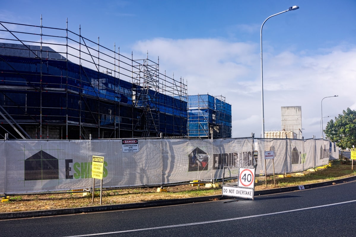 The exterior of a commercial construction site, enclosed by privacy fencing, illustrating effective fencing strategies for large-scale commercial projects.