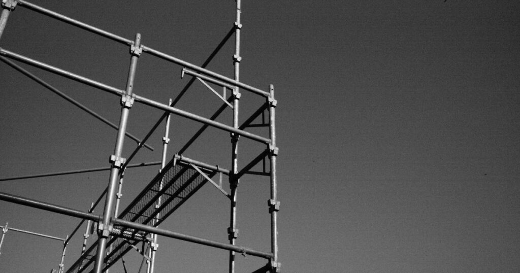Top 10 Scaffolding Parts All Builders Should Know for Safe Construction 8 A black and white image of a scaffold shows standards - the vertical part of the scaffolding.