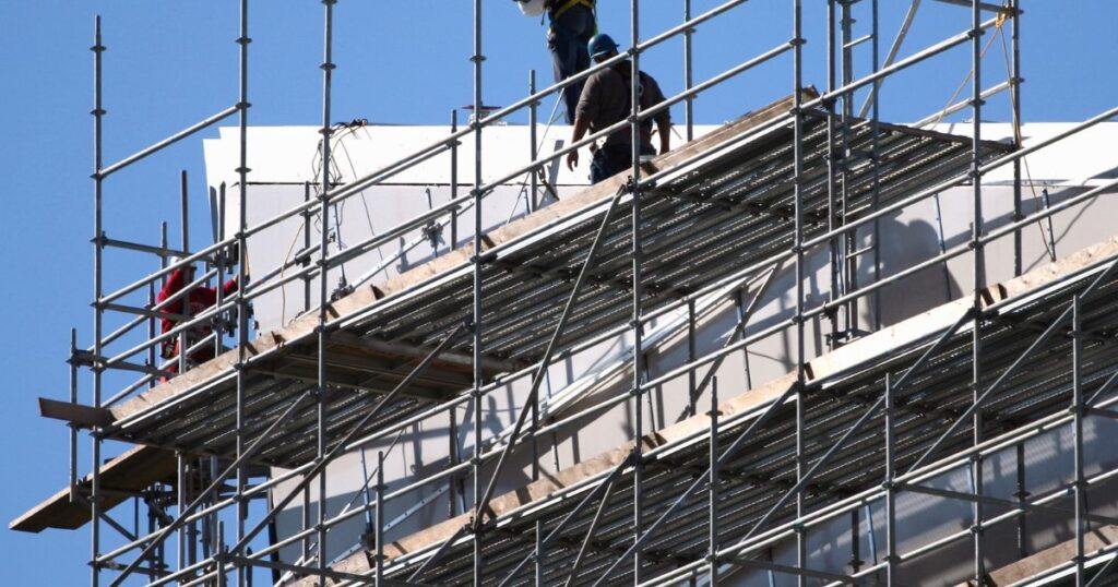Top 10 Scaffolding Parts All Builders Should Know for Safe Construction 7 Workers are erect scaffolding, showing how transoms support scaffold planks.